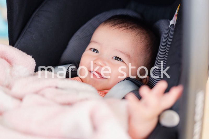 ベビーカーからほほえむ赤ちゃん