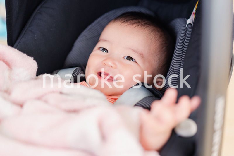 ベビーカーからほほえむ赤ちゃん