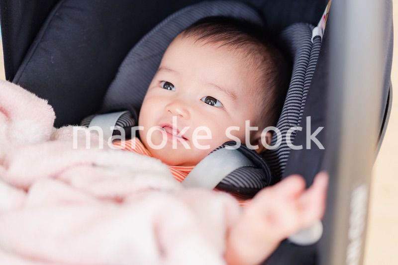 ベビーカーからほほえむ赤ちゃん