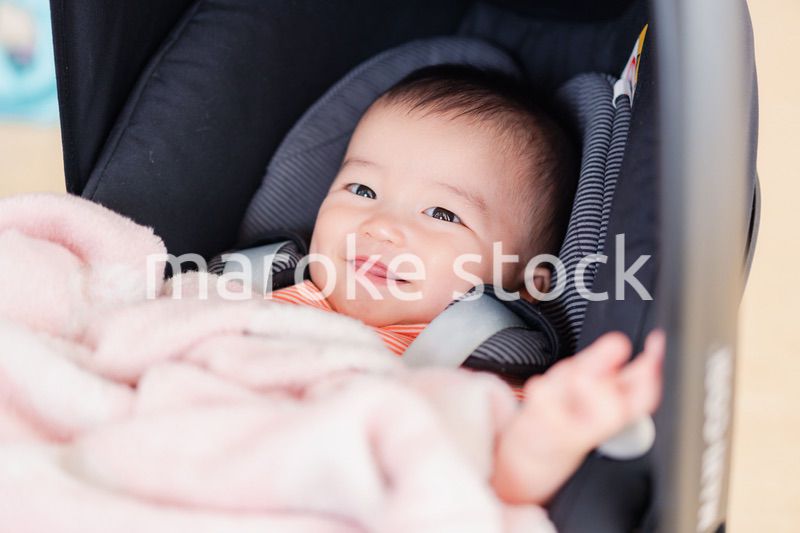 ベビーカーからほほえむ赤ちゃん