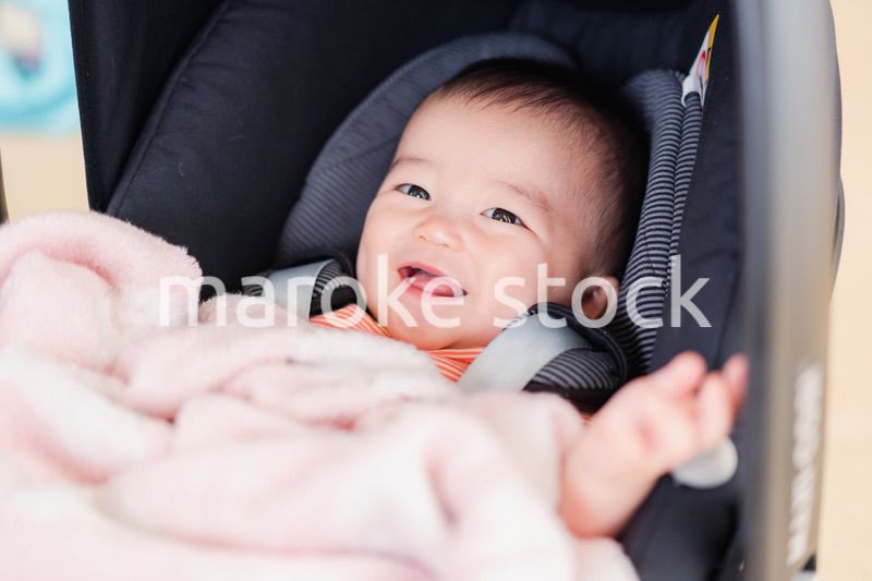 ベビーカーからほほえむ赤ちゃん