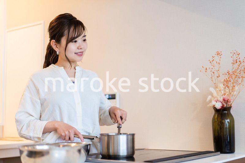 おうちのキッチンで料理をする主婦