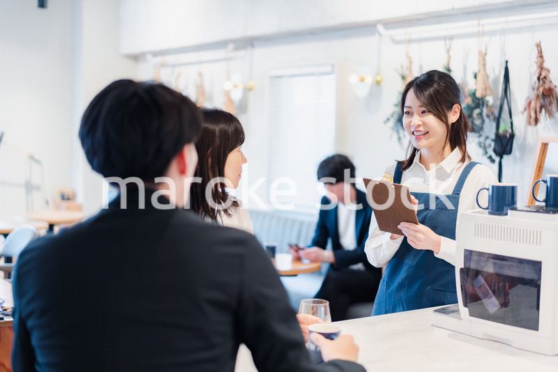 カフェで注文を取る若いスタッフ