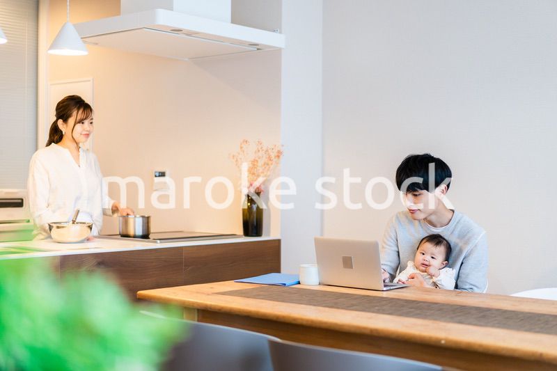 赤ちゃんと一緒にパソコンを使うパパ