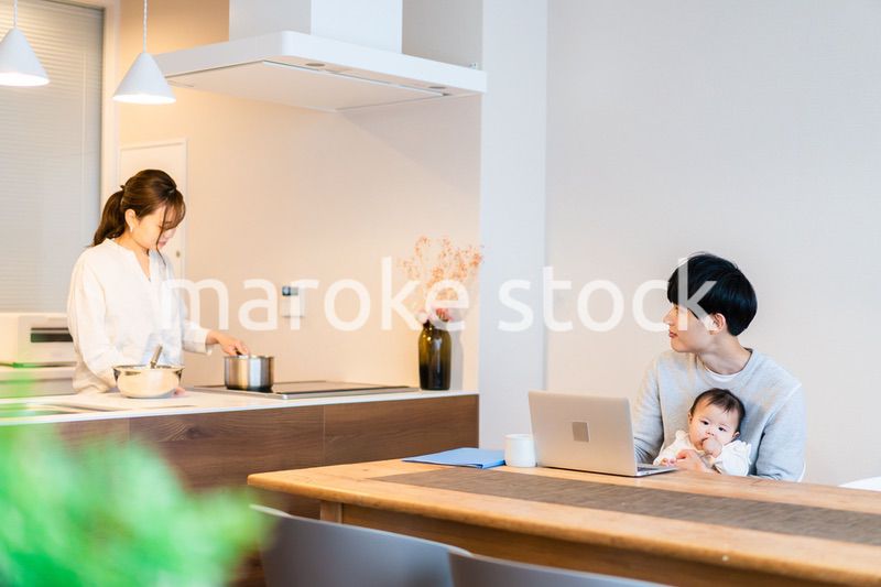 赤ちゃんと一緒にパソコンを使うパパ