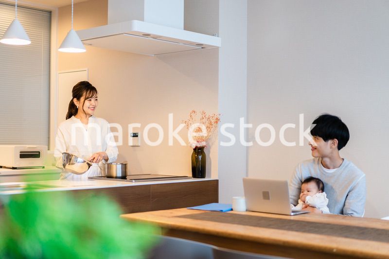 赤ちゃんと一緒にパソコンを使うパパ