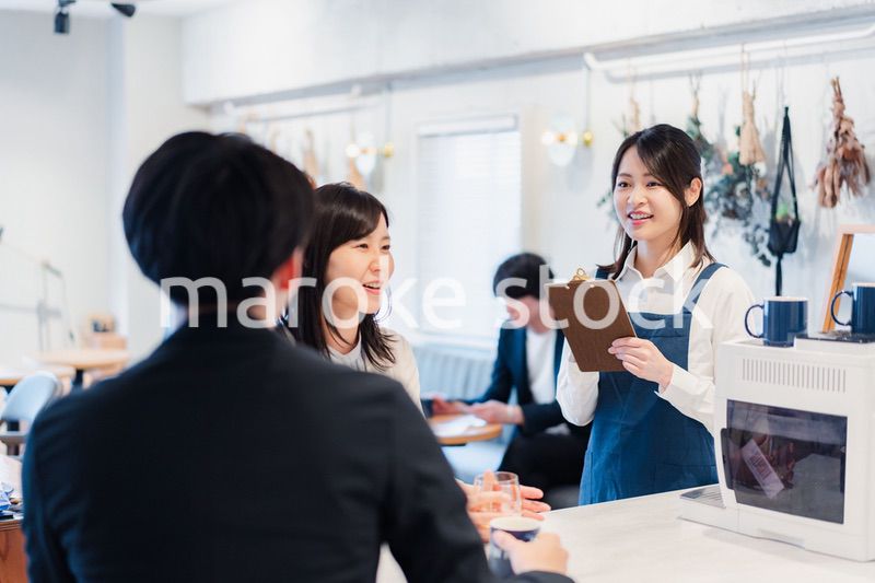 カフェで注文を取る若いスタッフ
