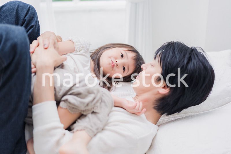 パパと一緒にベッドで遊ぶ小さな女の子