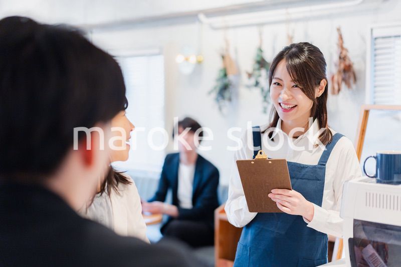 カフェで注文を取る若いスタッフ