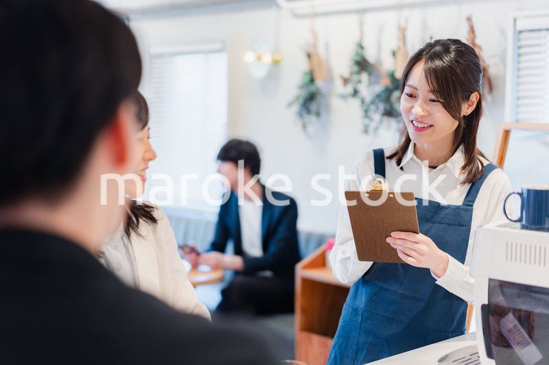 カフェで注文を取る若いスタッフ