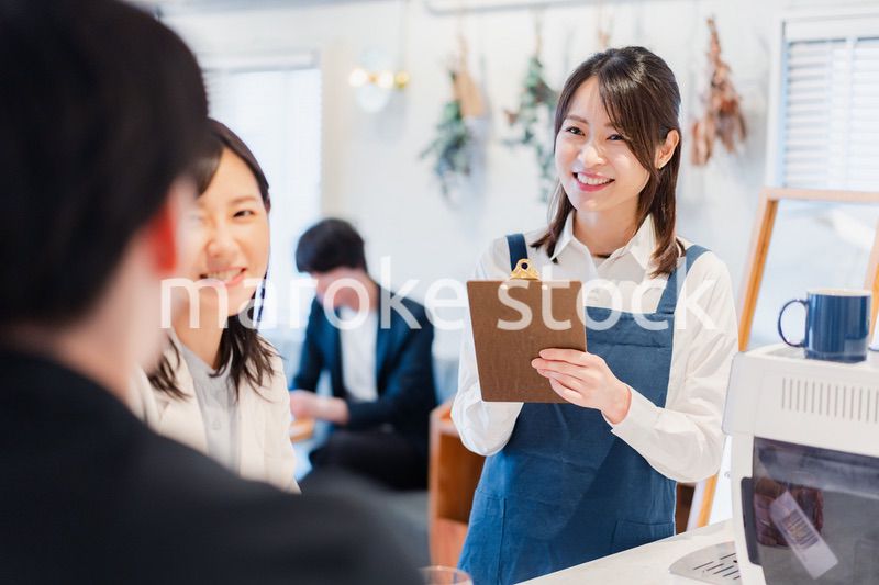 カフェで注文を取る若いスタッフ