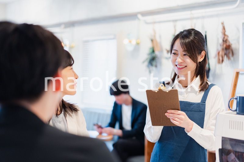 カフェで注文を取る若いスタッフ