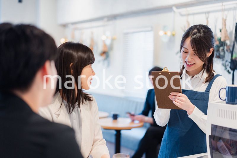 カフェで注文を取る若いスタッフ