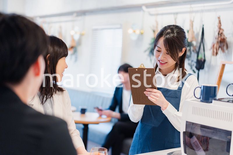 カフェで注文を取る若いスタッフ