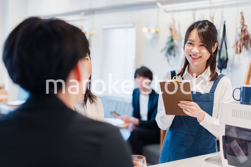 カフェで注文を取る若いスタッフ