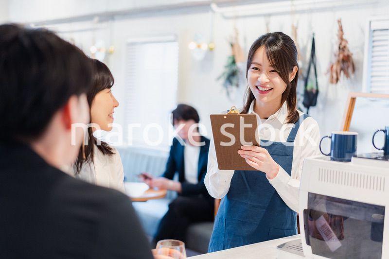 カフェで注文を取る若いスタッフ