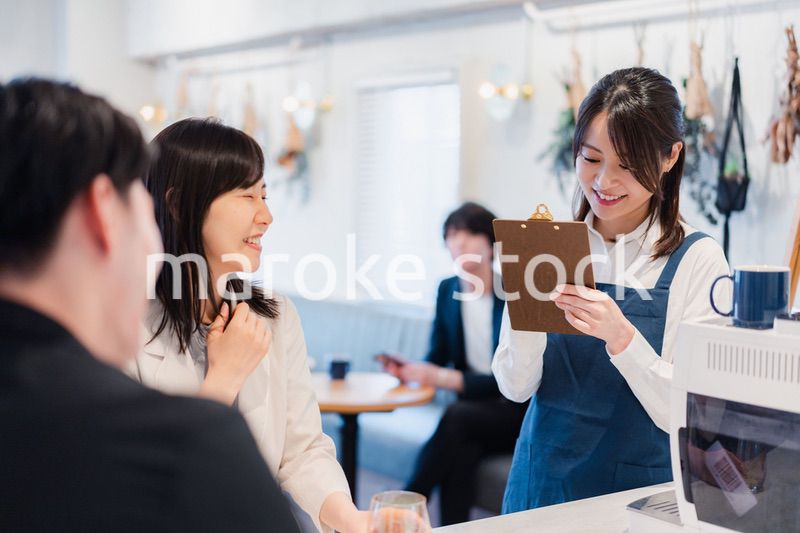 カフェで注文を取る若いスタッフ