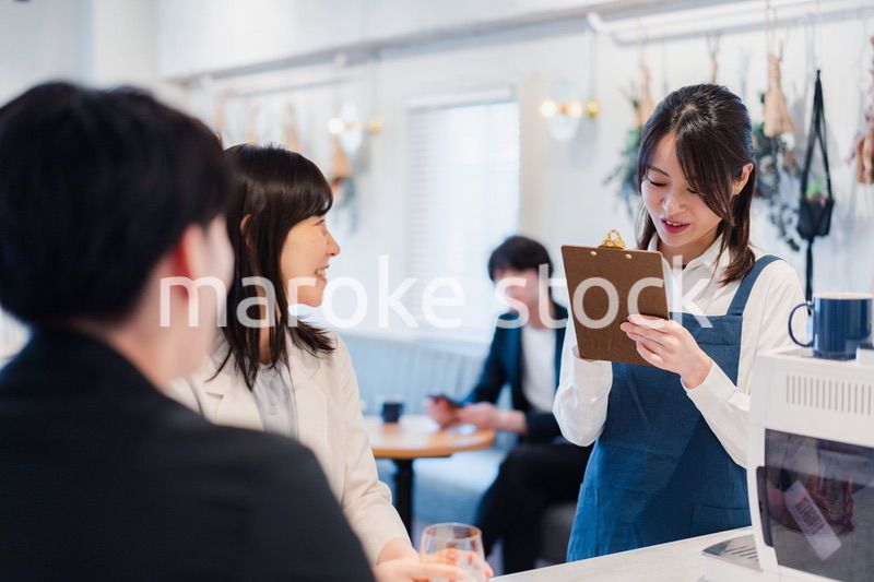 カフェで注文を取る若いスタッフ