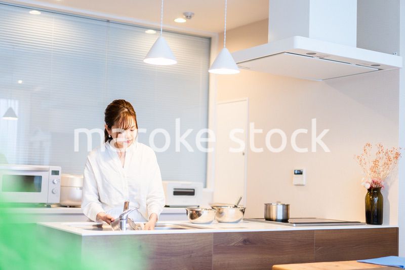 おうちのキッチンで料理をする主婦