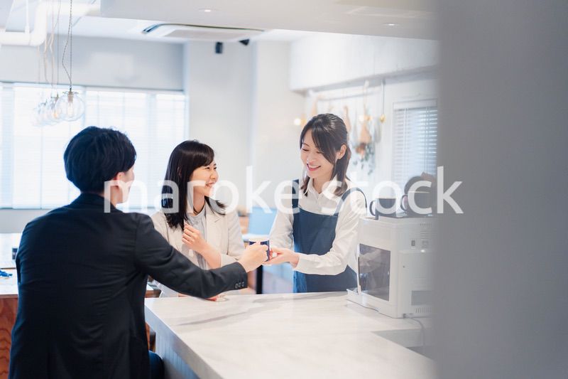 カフェで注文を取る若いスタッフ