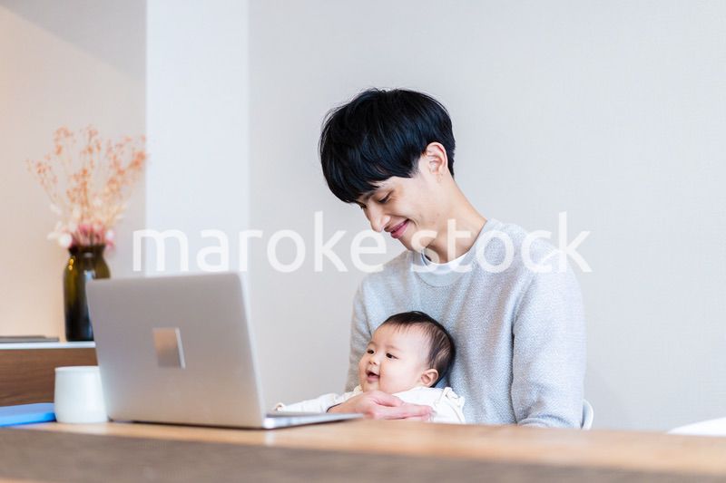 赤ちゃんをお世話しながら在宅勤務をするパパ