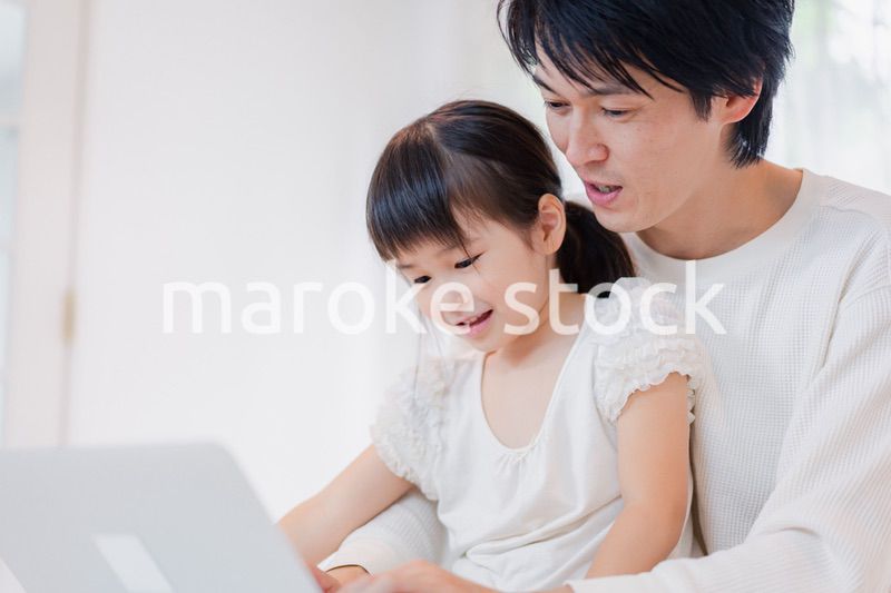 お父さんと一緒にパソコンを使う小さな女の子