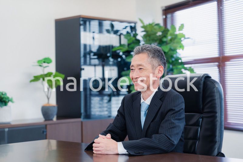 笑顔で椅子に座る経営者の男性