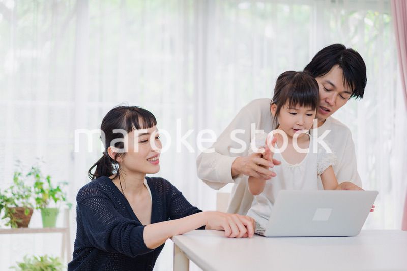 子供と一緒にパソコンで遊ぶ家族