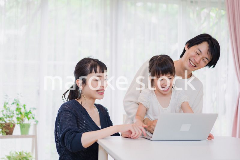 子供と一緒にパソコンで遊ぶ家族