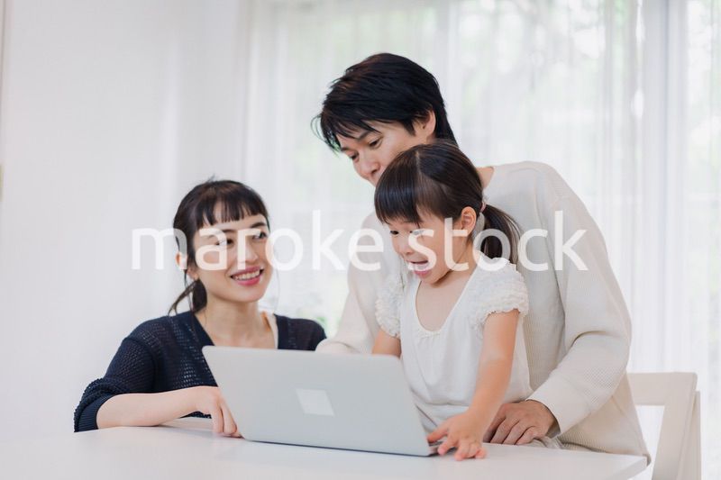 子供と一緒にパソコンで遊ぶ家族