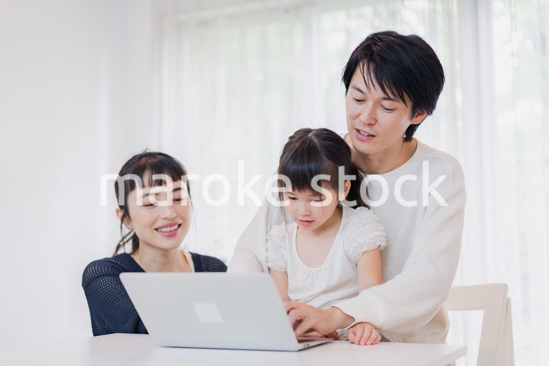 子供と一緒にパソコンで遊ぶ家族