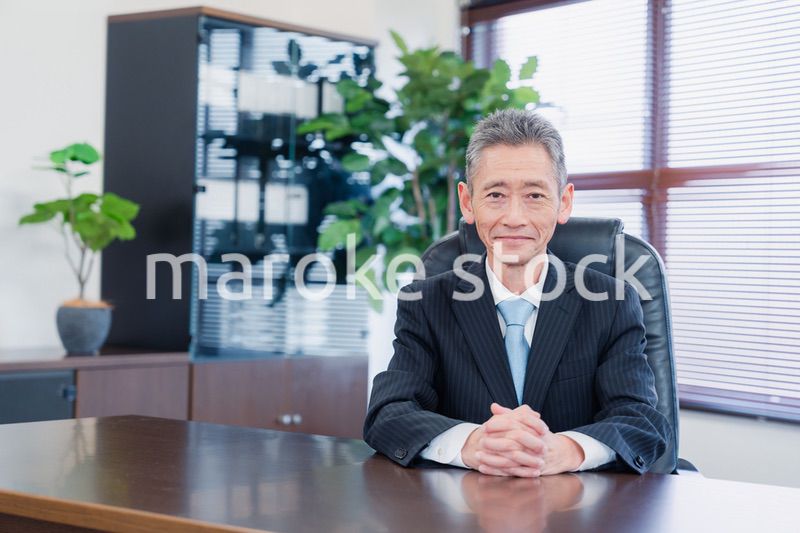 笑顔で椅子に座る経営者の男性