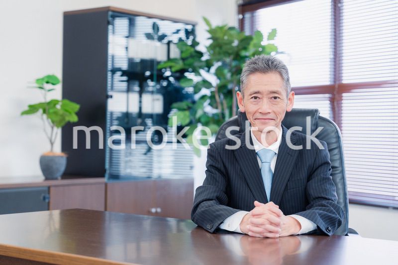 笑顔で椅子に座る経営者の男性