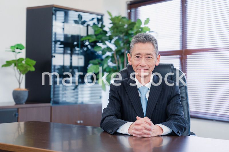 笑顔で椅子に座る経営者の男性