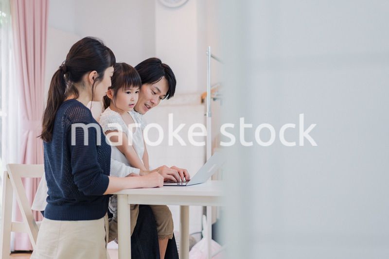 子供と一緒にパソコンで遊ぶ家族