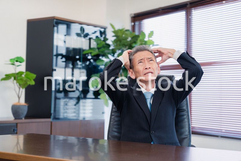 業績不振に頭を抱える経営者の男性