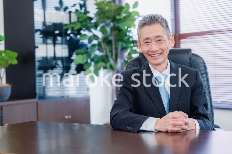 笑顔で椅子に座る経営者の男性