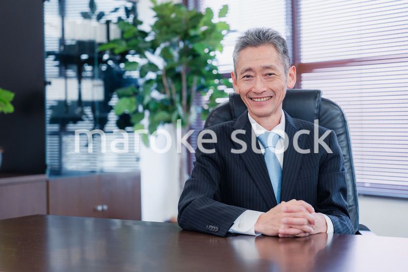 笑顔で椅子に座る経営者の男性