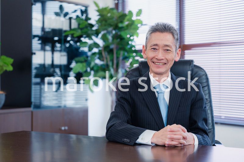 笑顔で椅子に座る経営者の男性