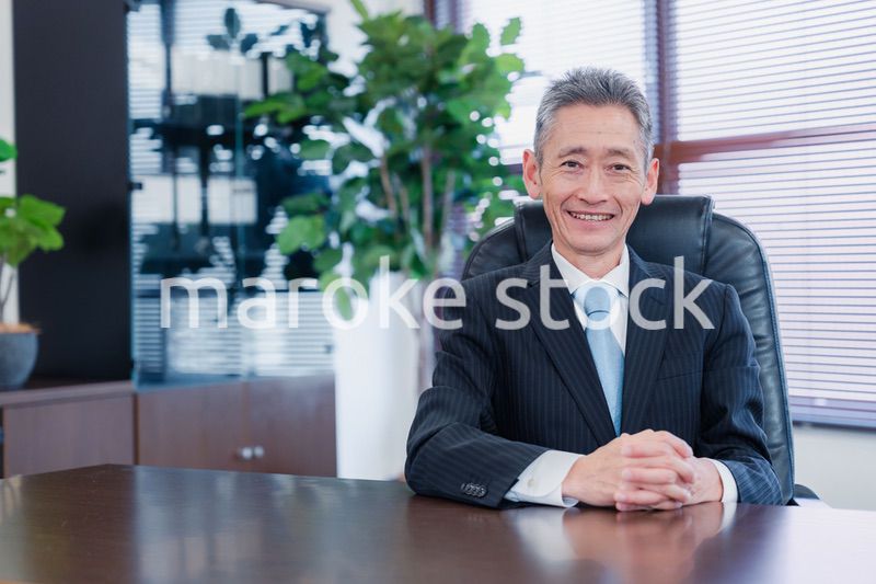笑顔で椅子に座る経営者の男性