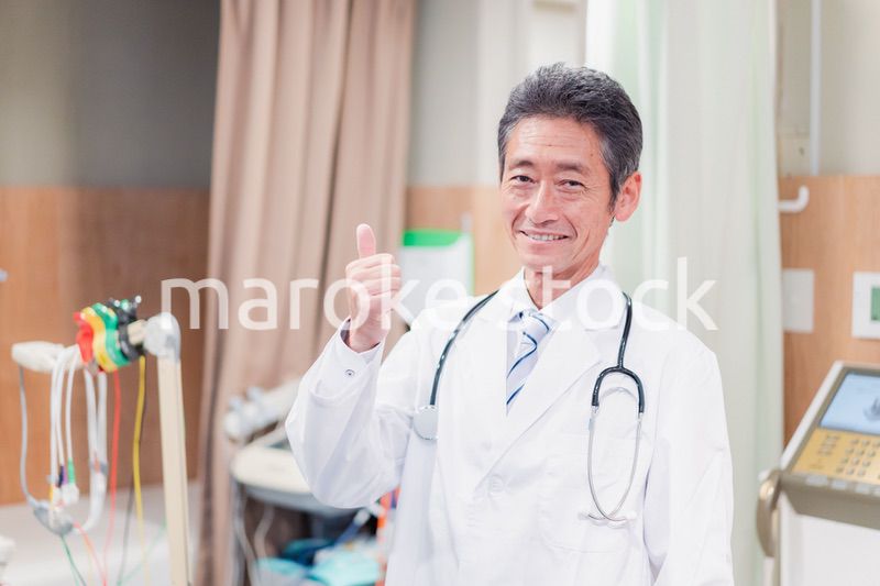 グッドサインをするベテランのドクター