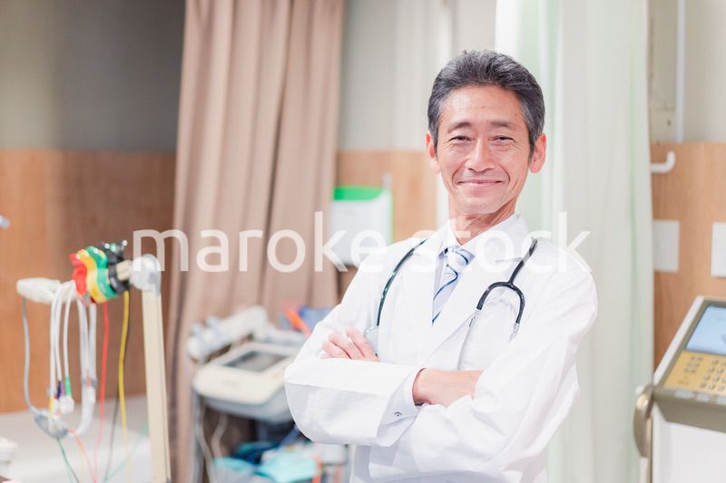 笑顔で腕を組む名医