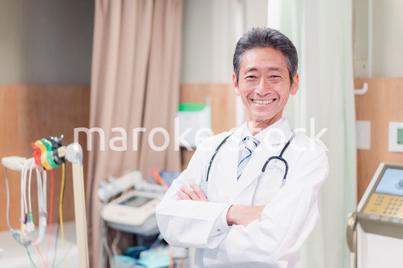 笑顔で腕を組む名医