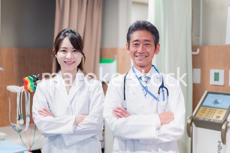 笑顔で腕を組む2人のドクター