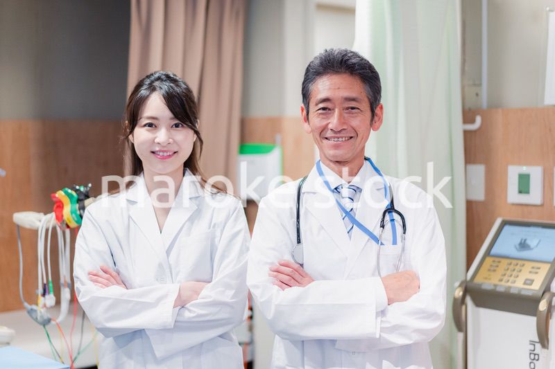 笑顔で腕を組む2人のドクター