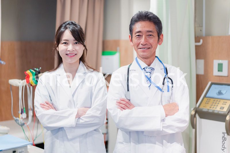 笑顔で腕を組む2人のドクター