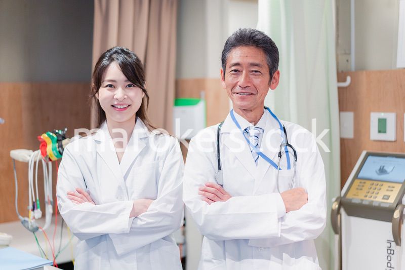 笑顔で腕を組む2人のドクター