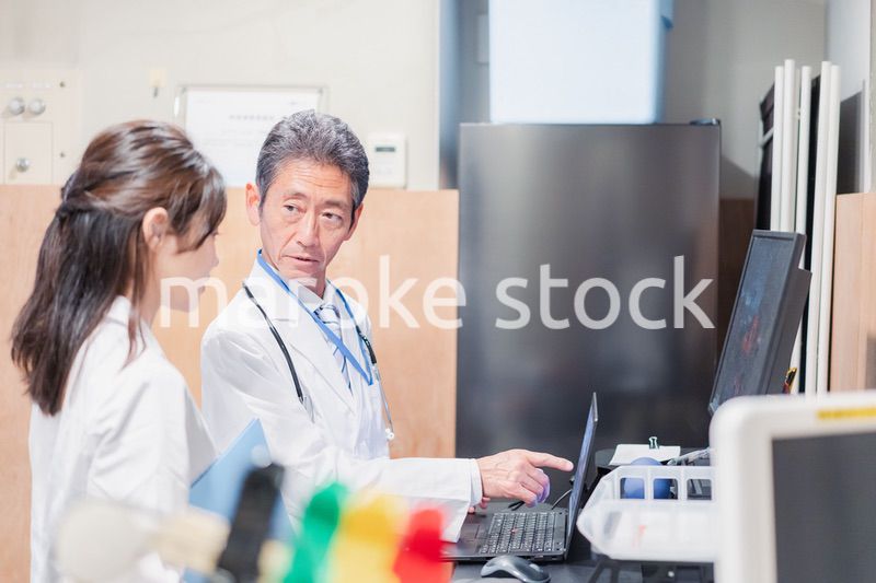 ナースステーションで打ち合わせをする医療従事者たち