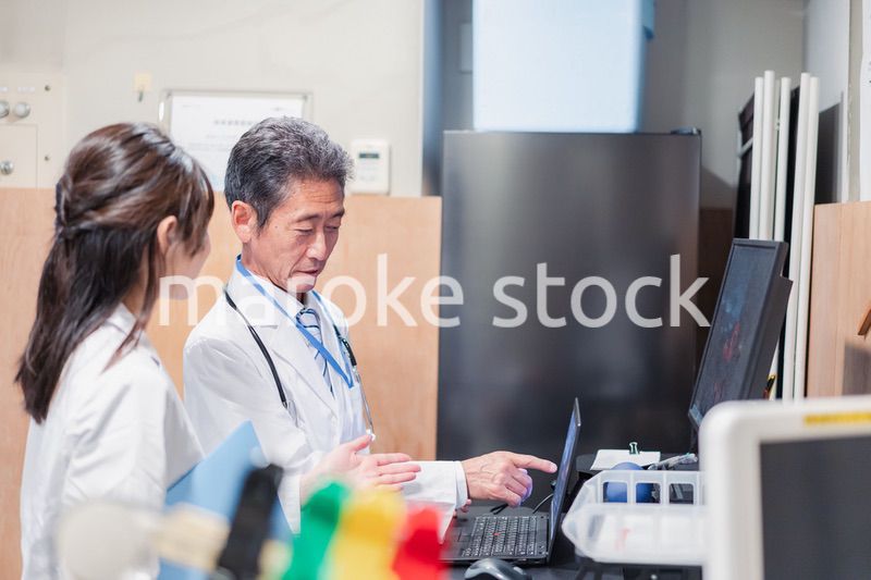 ナースステーションで打ち合わせをする医療従事者たち