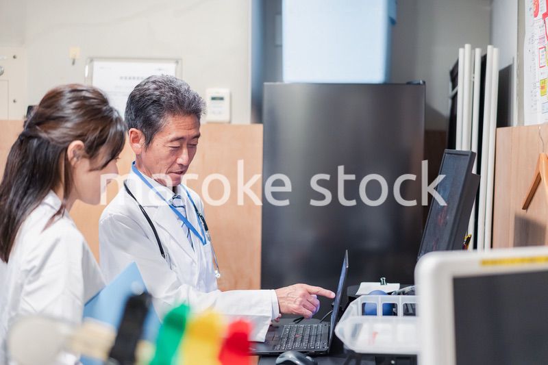 ナースステーションで打ち合わせをする医療従事者たち